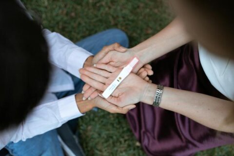 Man and woman looking down at a pregnancy test.