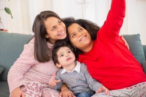 Two women taking a photo with a toddler