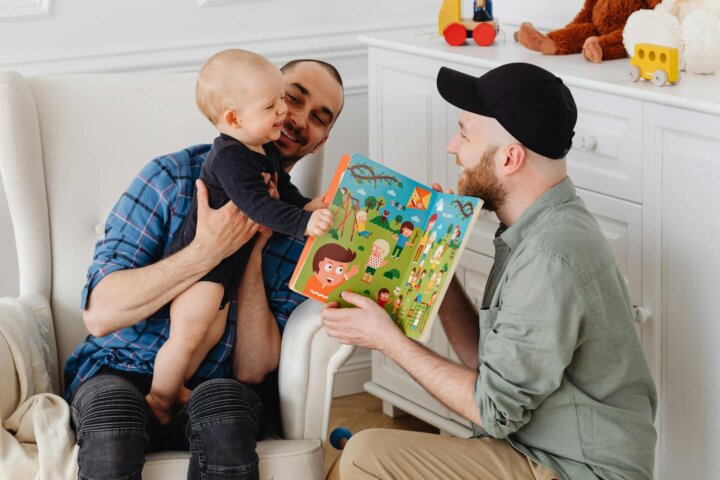 Two men playing with a baby after exploring LGBTQ+ family-building options