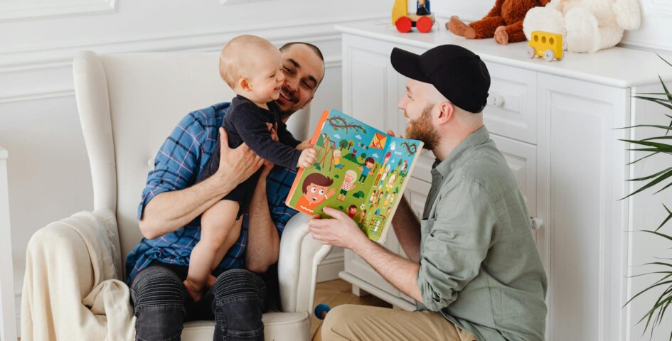 Two men playing with a baby after exploring LGBTQ+ family-building options