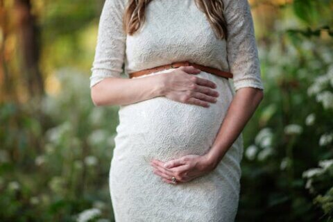 A pregnant lady holding her belly