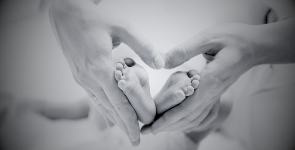 Parent holding baby feet after IVF success.